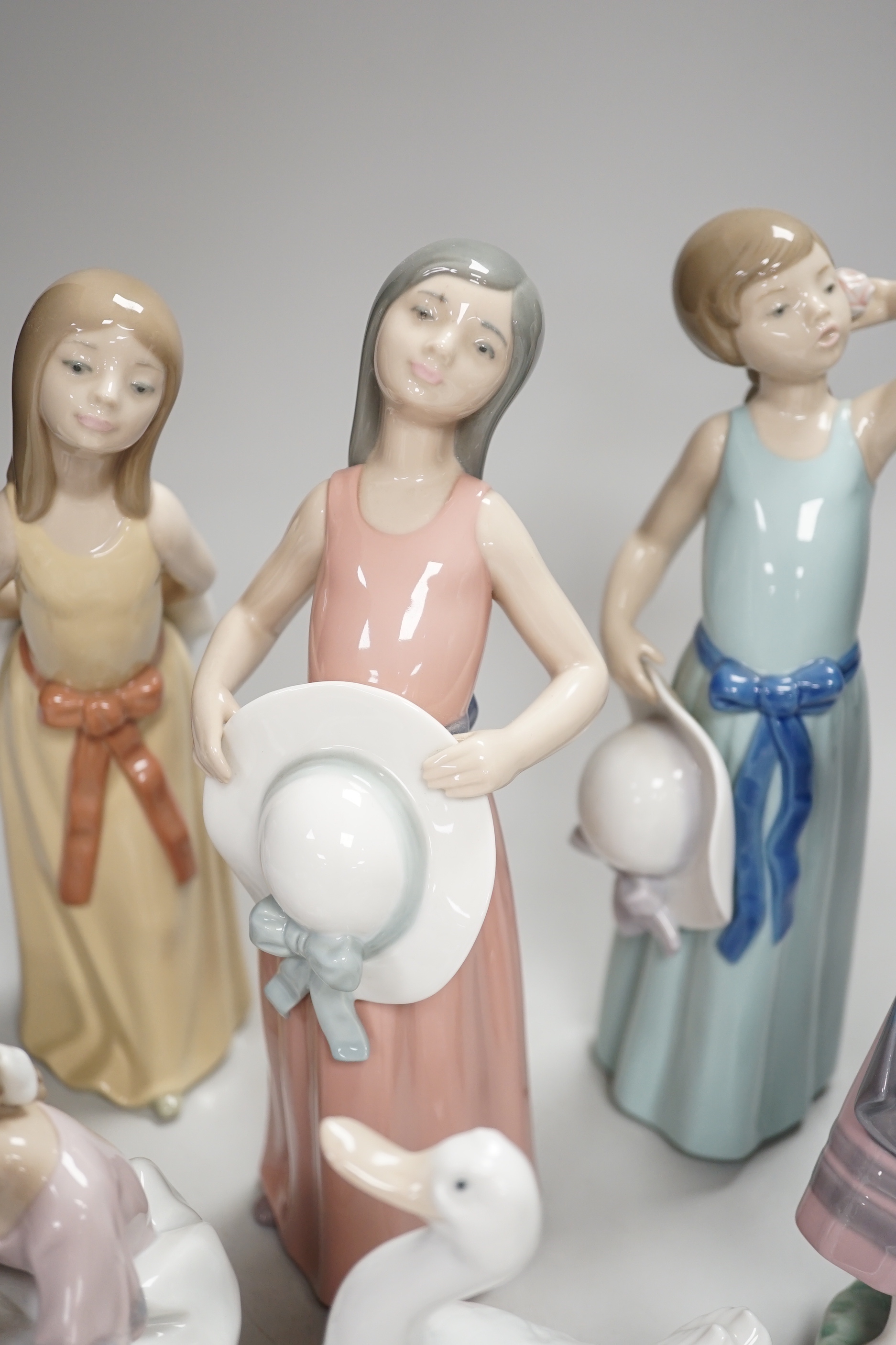 Six Lladro figures of girls, three with hats, one with a Teddy, two peasant girls with flowers and two Nao ducks, the largest 26cm high (8)